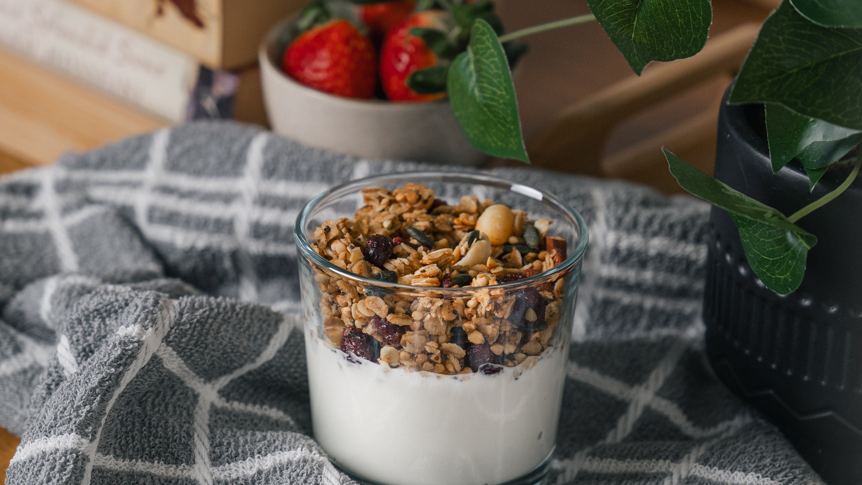 Nom Granola healthy breakfast with yogurt and fresh strawberries