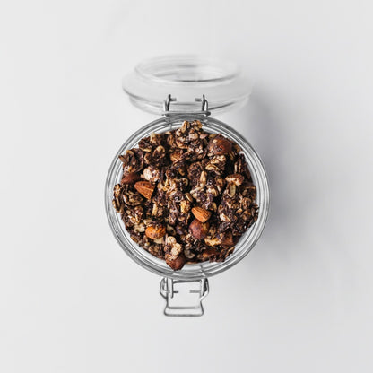 Cacao + Orange + Espresso artisan granola in a glass jar honey sweetened with buckwheat hazelnuts almonds dates and dark chocolate