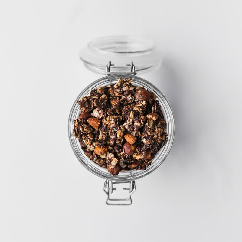 Cacao + Orange + Espresso artisan Nom Granola in a glass jar honey sweetened with buckwheat hazelnuts almonds dates and dark chocolate